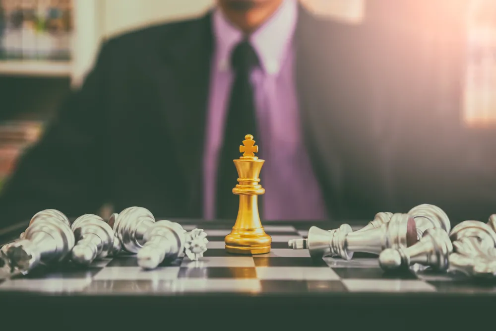 Chess game on chess board behind business man background. Business concept to present financial information and marketing strategy analysis. Investment target in global economy and digital commercial.
